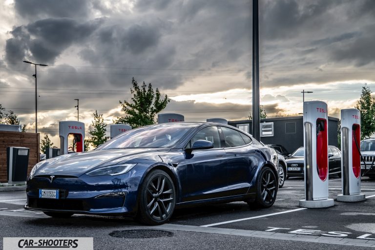 Tesla Model S Plaid &ndash; front three-quarter, blue metallic at a supercharger station