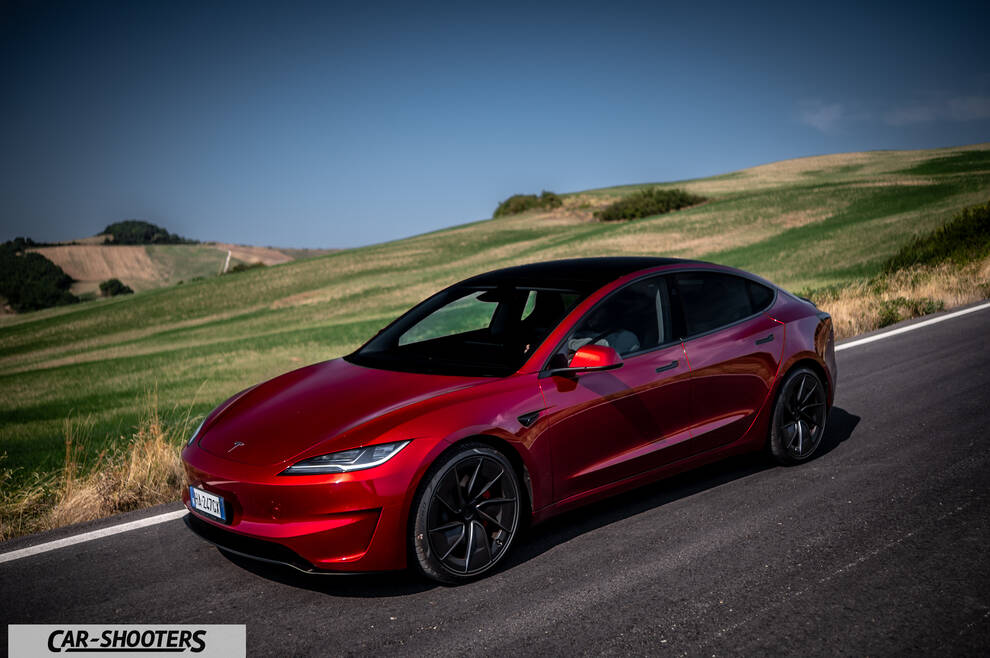 Tesla Model 3 Performance – front three-quarter, red on a country road